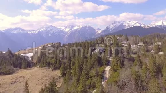 快速飞越美丽的维利卡平原充满云杉小房子和山脉在后面空中照相机视频的预览图