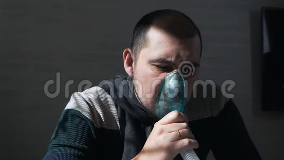 一个病人穿着毛衣和围巾坐在沙发上用吸入器感冒疾病流感治疗视频的预览图