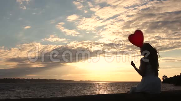 日落时带着红色气球的可爱女人视频的预览图