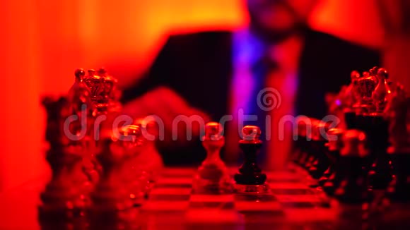 特写一个穿着商务服的男人的手坐在模糊的背景上下棋视频的预览图