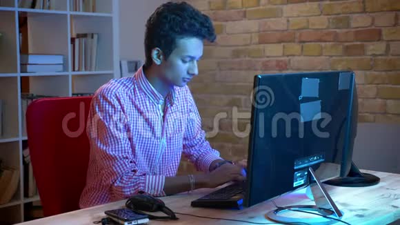 坐在舒适公寓里的年轻印度男程序员电脑打字特写镜头视频的预览图