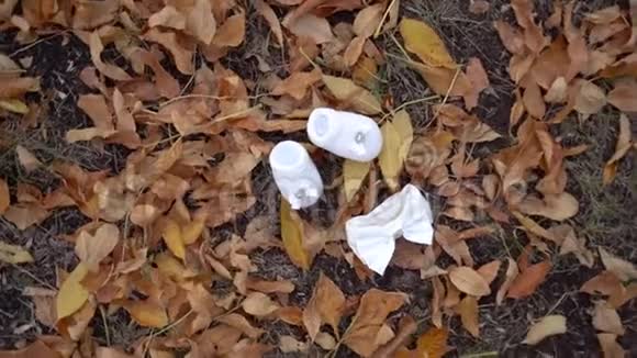 婴儿鞋和蝴蝶结躺在落叶上视频的预览图