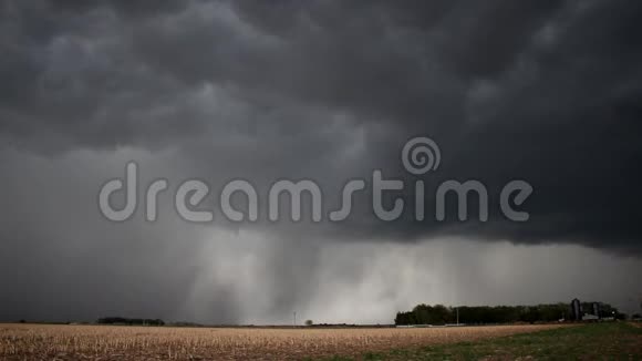 时间流逝的黑暗动荡的风暴云倾倒大雨在农田视频的预览图