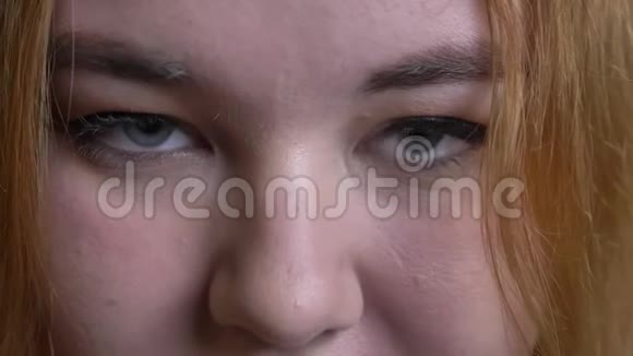 年轻迷人的超重女性面部特写镜头灰色眼睛直视镜头沉思视频的预览图