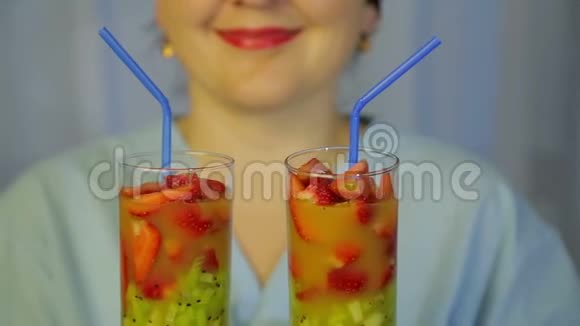 一个女厨师手里拿着一杯新鲜猕猴桃和草莓的鸡尾酒视频的预览图