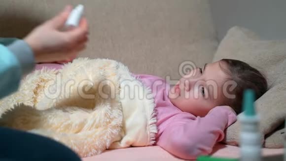 年轻的母亲滴着生病的女儿滴在鼻子里视频的预览图