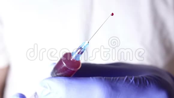 医生他的手从注射器里释放出多余的血液视频的预览图