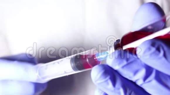 医生他的手在注射器里装满了红色疫苗准备给病人注射视频的预览图