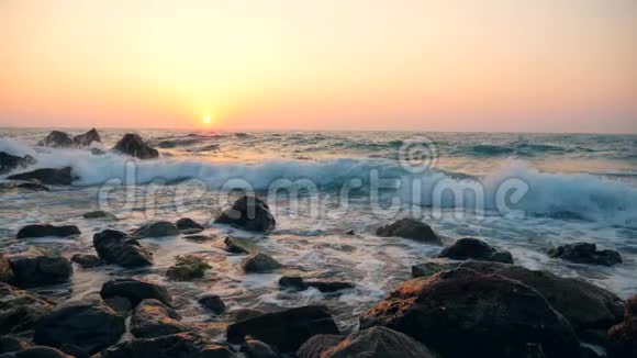 日落背景下白色波浪撞击海岸线动作缓慢视频的预览图