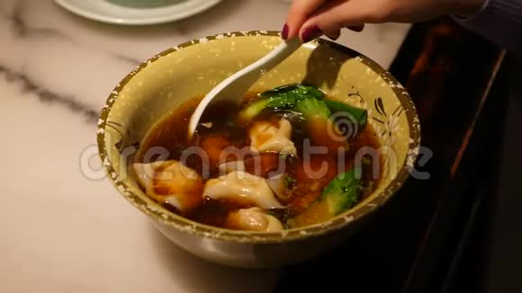 女人吃美味的中国饺子汤视频的预览图
