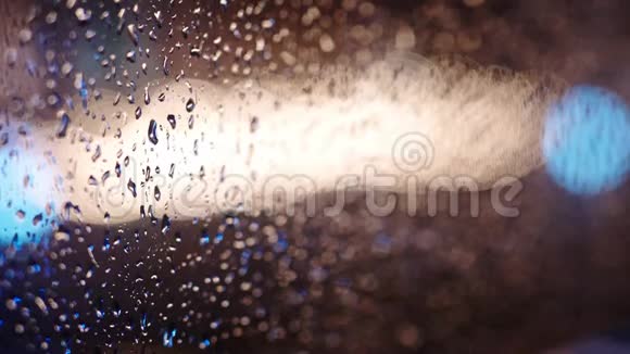 窗玻璃上五颜六色的雨滴视频的预览图