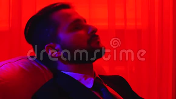 长胡子的人靠在椅子上上班族累了在红灯下射击视频的预览图