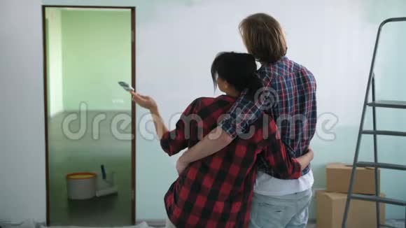 恋爱中的情侣拥抱看着彩绘的墙壁视频的预览图