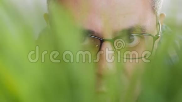 一个人的脸在草丛中窥视视频的预览图