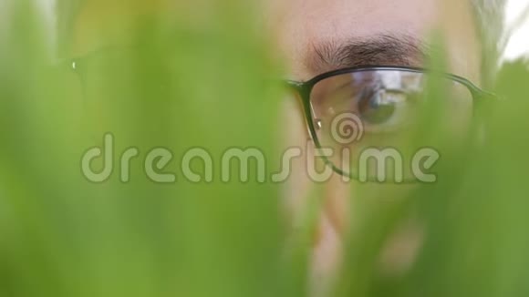 一个人的脸在草丛中窥视视频的预览图