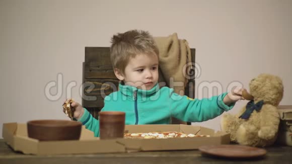 小男孩用勺子喂玩具朋友孩子和泰迪熊朋友共进晚餐好好吃一口可爱视频的预览图