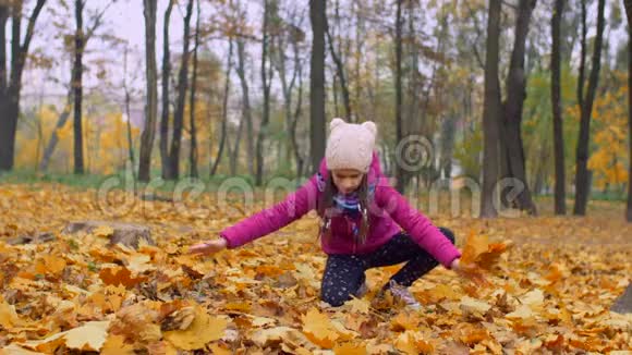 令人兴奋的女孩在公园里投掷秋天落叶视频的预览图