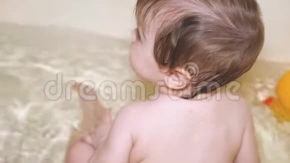 快乐的宝宝在水里玩玩具孩子在浴室里洗澡视频的预览图