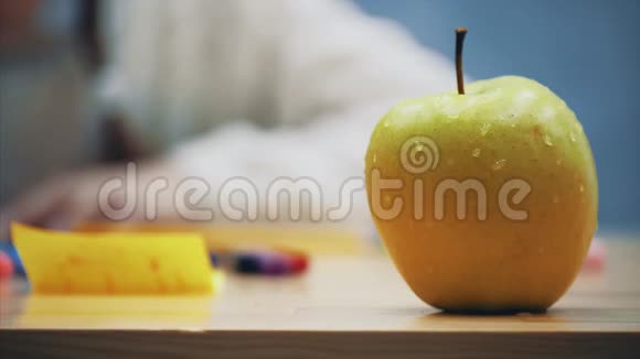 大的多汁的黄色苹果在最前面和手的女学生谁拿它品尝视频的预览图
