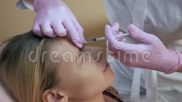 美容诊所美容师用手套在女性皮肤上进行面部老化注射女人做美容视频的预览图