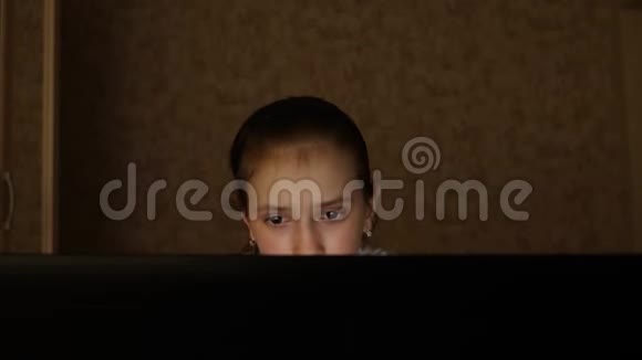 一个年轻的女孩晚上在房间里看电脑屏幕眼睛很累疲惫的少女看着屏幕视频的预览图