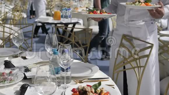 自助餐厅和酒店饮食服务服务员在婚礼或研讨会上把盘子和盘子放在客人的桌子上视频的预览图