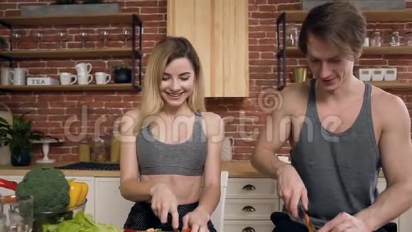 这对年轻夫妇正在家中的厨房里切菜用来做沙拉健康食品和视频的预览图