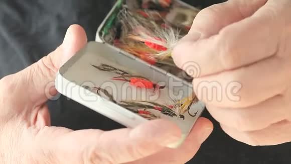 渔夫检查他的人造苍蝇收藏视频的预览图