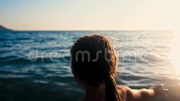 快乐的孩子在美丽的夕阳下跑进大海的剪影婴儿在沙滩向水冲去后方视频的预览图