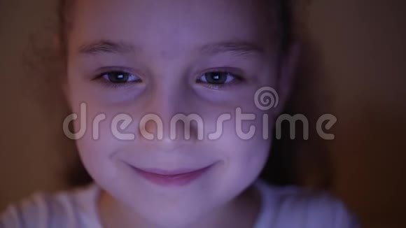 一个可爱的白种人小女孩特写一个孩子的的脸看着一台平板电脑与光和反射视频的预览图