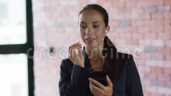 年轻女商人用耳机打电话视频的预览图