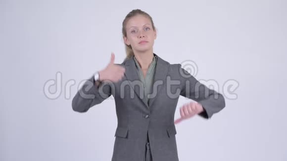 年轻迷茫的金发女商人在竖起大拇指和竖起大拇指之间做出选择视频的预览图