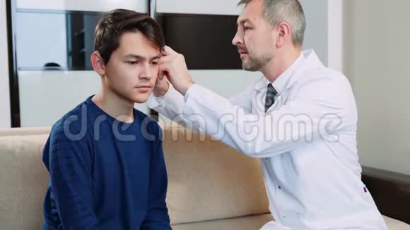 医生给一个十几岁的孩子戴上耳后助听器视频的预览图