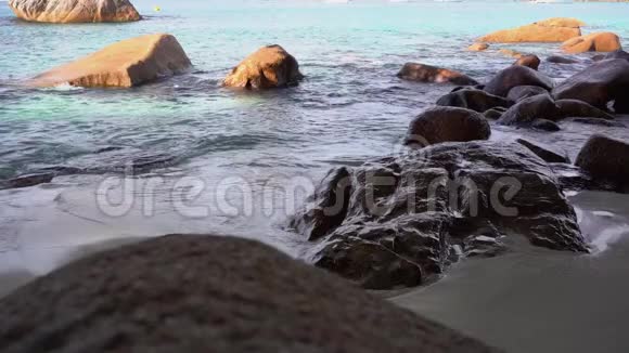 塞舌尔普拉斯林岛波浪在沙滩上滚着石头热带海岛豪华度假旅游放松视频的预览图