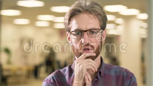 一幅蓄胡子的男子在镜头中紧张地靠近他的脸的肖像视频的预览图