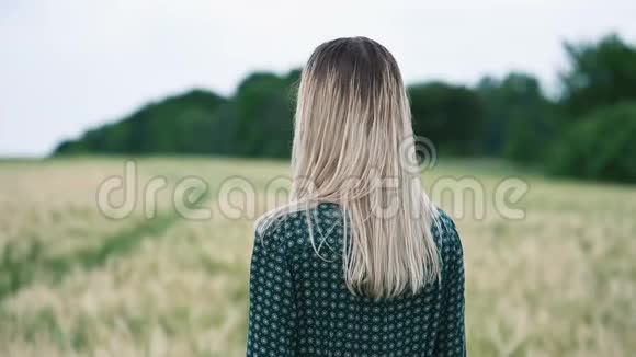 一个快乐迷人的白人金发女孩的肖像在雨中湿发在大自然女孩打开了摄像机视频的预览图