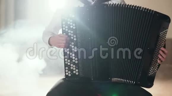 音乐家在舞台灯光阴影下手手风琴特写视频的预览图
