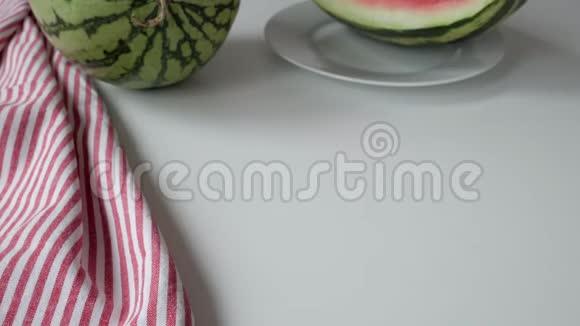 女人的手把盘子放在桌上上面放着成熟的红色西瓜片视频的预览图