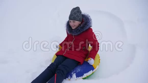 冬天的年轻快乐的女孩在白雪上用飞碟雪旋转笑了起来度假的女人微笑着玩视频的预览图