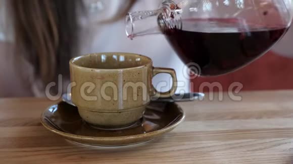 女孩把红茶倒入咖啡杯视频的预览图