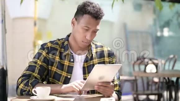 使用平板电脑的非洲年轻人户外咖啡馆视频的预览图