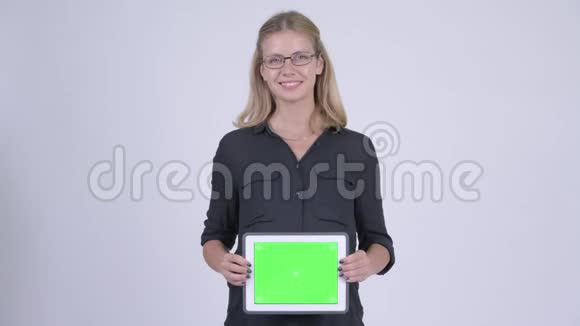 年轻快乐的怀孕女商人展示腹部数字平板电脑视频的预览图