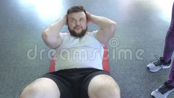 一个长着胡须的白种人在健身教练的监督下为腹部做运动视频的预览图