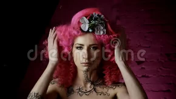 一个美丽的女孩的肖像卷曲的粉红色头发时尚的发型我知道视频的预览图