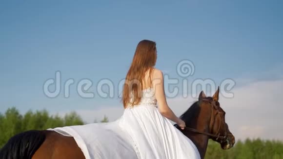 穿着新娘白色礼服的女孩骑着马慢动作视频的预览图