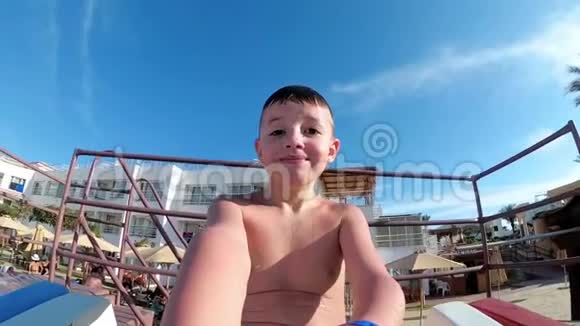 快乐男孩滑下滑水道在埃及的一家旅馆里和他一起自拍慢动作视频的预览图