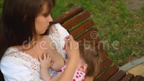 妈妈给婴儿喂奶抚摸他的头婴儿躺在手中喝母乳奶视频的预览图