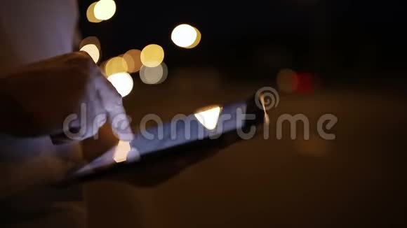男子夜间在路边触摸平板电脑视频的预览图