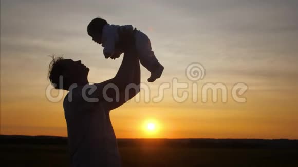 爸爸在日落时抱着婴儿转圈慢动作视频的预览图