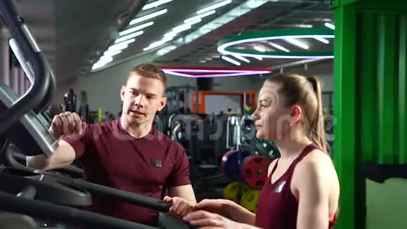 人们在健身房锻炼机器女培训配个人健身指导员视频的预览图